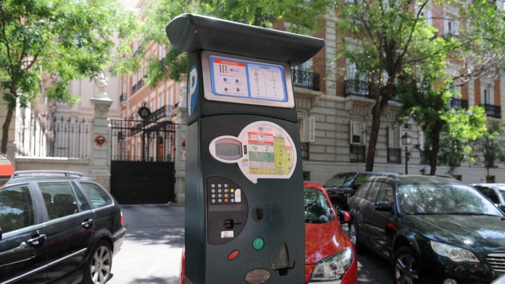 Parquímetro de la zona SER en una calle de Madrid, con coches aparcados detrás