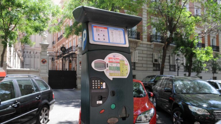 Parquímetro de la zona SER en una calle de Madrid, con coches aparcados detrás